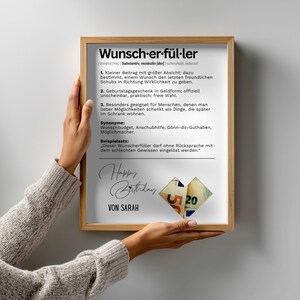 May include: A framed print with the German word "Wunscherf&uuml;ller" at the top, meaning "wish fulfiller". The print includes definitions, synonyms, and a sample sentence. The words "Happy Birthday" and "Von Sarah" are also visible.