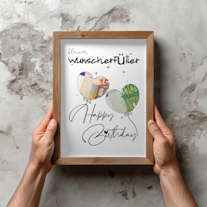 K&ouml;nnte beinhalten: Ein Holzrahmen mit einem wei&szlig;en Druck, der den schwarzen Schriftzug "kleiner Wunscherf&uuml;ller" und "Happy Birthday" in Schreibschrift zeigt. Abgebildet sind zwei herzf&ouml;rmige Luftballons, gef&uuml;llt mit einem F&uuml;nf-Euro-Schein und einem Hundert-Euro-Schein.