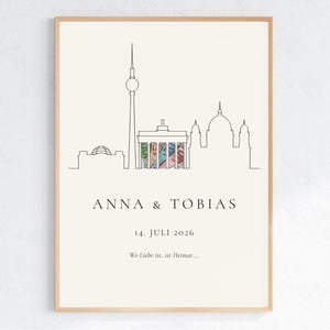 Berlin Skyline Geldgeschenk zur Hochzeit – Brandenburger Tor, Fernsehturm, Reichstag und Berliner Dom als minimalistische Linienzeichnung in Creme und Schwarz, im Rahmen an der Wand. Personalisiertes DIY Hochzeitsgeschenk DIN A4 PDF für das Brautpaar.