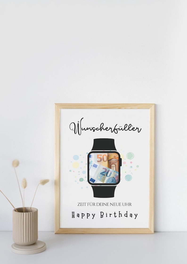 May include: A framed print featuring a black smartwatch illustration with Euro banknotes visible on the screen. The text reads Wunscherf&uuml;ller, ZEIT F&Uuml;R DEINE NEUE UHR, and Happy Birthday, surrounded by small colorful circles on a white background.