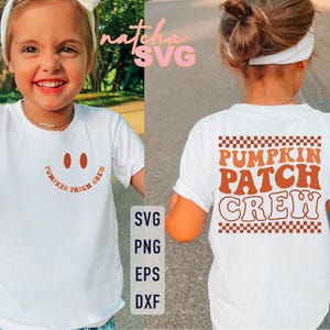 May include: A white t-shirt with a smiling face design and the words "Pumpkin Patch Crew" in orange. The back of the shirt also features the words "Pumpkin Patch Crew" in orange with a checkered pattern above and below.