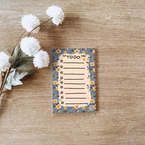 May include: A blue and white floral patterned notepad with a checklist and the word "TODO" at the top.