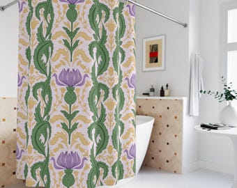 May include: A floral shower curtain featuring a repeating pattern of purple thistle flowers, green leaves, and gold accents on a light pink background. The curtain is hanging in a bathroom setting.