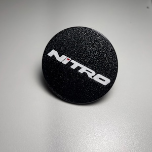 May include: Black round sticker with the word "NITRO" in white letters with a red dot in the "I".