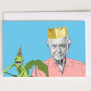 Puede incluir: Tarjeta de felicitación con un retrato de un hombre con una corona dorada y un lagarto verde con un gorro de fiesta. La tarjeta tiene un fondo azul claro y un sobre blanco.
