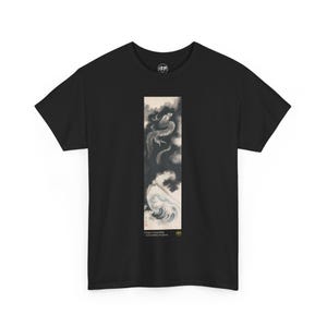 Puede incluir: Camiseta negra con un estampado gráfico de un dragón que emerge de una ola. El texto "Dragon Ascending" y "Katsushika Hokusai" están impresos debajo de la imagen.