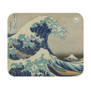 Puede incluir: Posavasos cuadrado con la icónica estampa japonesa "La Gran Ola de Kanagawa" de Hokusai. La imagen muestra una gran ola, barcos y el monte Fuji. El posavasos tiene un fondo gris claro.