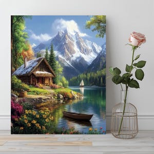 Peut inclure: Peinture de paysage encadrée représentant un lac de montagne serein. Une cabane en bois avec un toit enneigé est au bord du lac. Un voilier navigue sur l'eau, avec des montagnes enneigées en arrière-plan. Une rose dans un vase en verre est au premier plan.