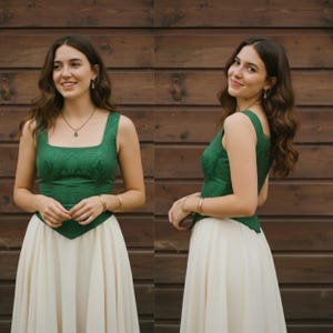 May include: A sleeveless bodice in a deep emerald green fabric with a subtle tonal pattern, featuring a square neckline and a pointed hemline, paired with a long, flowing, off-white skirt that reaches below the knees in a simple, elegant design.