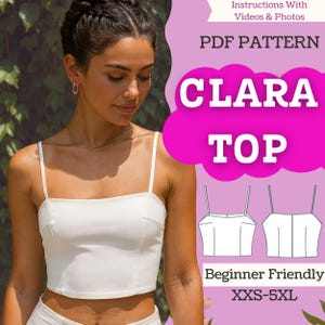 May include: A woman wearing a white camisole top. The image includes text that reads "CLARA TOP" and "PDF PATTERN". The top is a beginner-friendly pattern available in sizes XXS-5XL. The background features green foliage.