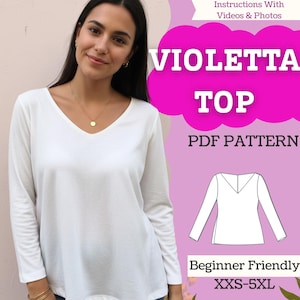 Op de afbeelding: Een witte top met lange mouwen en een V-hals. De afbeelding bevat de tekst "VIOLETTA TOP PDF PATTERN" en "Beginner Friendly XXS-5XL". Er is ook een lijntekening van de top te zien. De top wordt door een persoon gedragen.