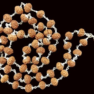 以下が含まれることがあります： 茶色で質感のあるビーズを銀色のチェーンに通したネックレス。ビーズは丸く、表面はざらざらしています。ネックレスは黒い背景に表示されています。
