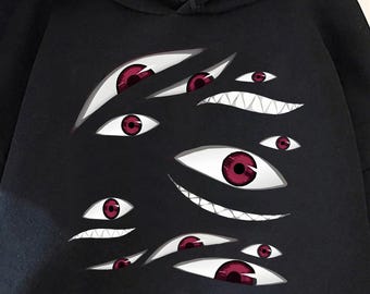 May include: Black hooded sweatshirt featuring a graphic of multiple red-eyed, stylized eyes. The sweatshirt has a front pocket and a drawstring hood. The design is centered on the front of the garment.