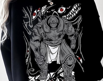 May include: Black sweatshirt featuring a detailed gray illustration of a character in armor, surrounded by stylized teeth and eyes. The design is a graphic print, with a white and gray color scheme. The sweatshirt is a casual garment.