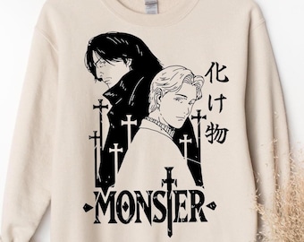 May include: A beige crewneck sweatshirt featuring a black graphic print of two anime-style characters, multiple sword silhouettes, the Japanese text 化け物, and the word MONSTER with a sword replacing the letter T.