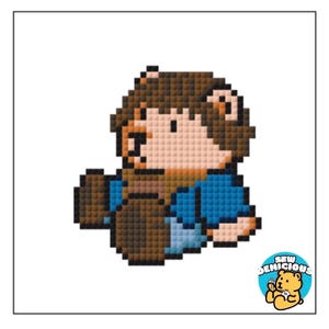 May include: Pixelated illustration of a bear-like character in brown, tan, and blue. The character is holding a brown object. The image has a white background and a logo in the bottom right corner that says "Sew Demicious".