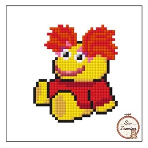 May include: A pixelated cross-stitch design of a cartoon character with a yellow face, red hair, and a red shirt. The character has a large smile and is sitting down. The image includes the text "Sew Demicious" in a circular logo.