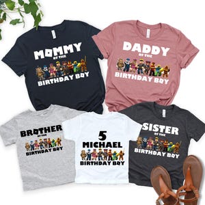 May include: Five short-sleeved t-shirts in various colors, including navy, pink, gray, white, and charcoal. Each shirt features a graphic of characters and the words "Mommy," "Daddy," "Brother," "Sister," or a name, with "Birthday Boy" below.