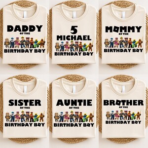 May include: Six beige t-shirts with black text and a colorful graphic of toy figures. The shirts read "DADDY", "5 MICHAEL", "MOMMY", "SISTER", "AUNTIE", and "BROTHER" above "BIRTHDAY BOY".