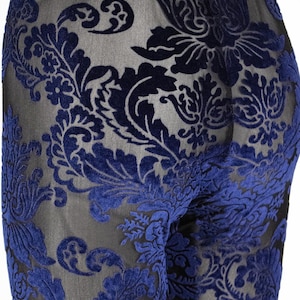 Puede incluir: Leggings de terciopelo azul con estampado y una superposición de malla transparente. El patrón es un diseño damasco tradicional.