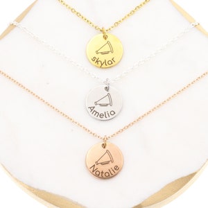 May include: Three gold, silver, and rose gold necklaces with a megaphone charm and personalized name tags. The names are Skylar, Amelia, and Natalie.