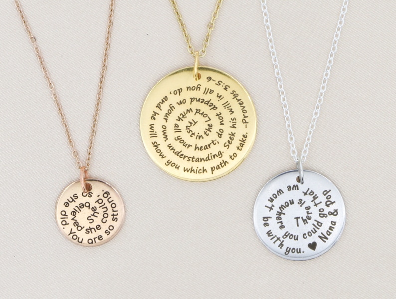 May include: Three silver necklaces with round pendants. The pendants have inspirational quotes engraved on them. The quotes are: "You are so precious she believed she could", "I know am I mom you be there for you", and "Seek his will in all you do, and he will show you which path to take. -Proverbs 9:10".
