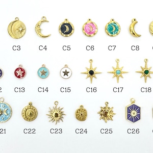 K&ouml;nnte beinhalten: Eine Sammlung goldfarbener Charms mit himmlischen und wetterbezogenen Designs. Zu den Charms geh&ouml;ren ein Blitz, Halbmonde, Sterne, Sonnen und ein Regenbogen. Jeder Charm ist mit einem "C" gefolgt von einer Nummer gekennzeichnet.