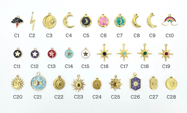 K&ouml;nnte beinhalten: Eine Sammlung goldfarbener Charms mit himmlischen und wetterbezogenen Designs. Zu den Charms geh&ouml;ren ein Blitz, Halbmonde, Sterne, Sonnen und ein Regenbogen. Jeder Charm ist mit einem "C" gefolgt von einer Nummer gekennzeichnet.