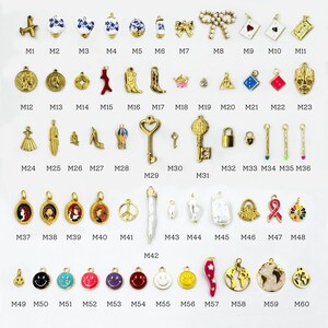 K&ouml;nnte beinhalten: Eine Sammlung goldfarbener Charms mit verschiedenen Designs, darunter ein Flugzeug, Blumen, eine Schleife, ein Schl&uuml;ssel, ein Schloss und ein Smiley. Einige Charms haben farbige Emaille-Details. Die Charms sind in Reihen und Spalten angeordnet.