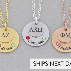 3 necklaces Gold Silver rose-gold. Each necklace has a dime sized disc stacked on a quarter sized disc. The small discs have 2-3 Greek letters engraved. The larger discs have names engraved along the bottom and birthstones glued on either side