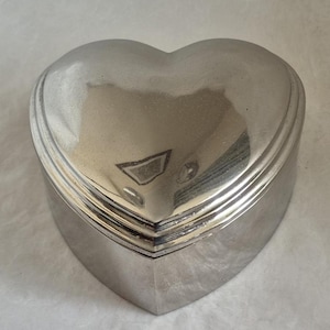 Heart shaped polished metal trinket box with delicate stepped edging to lid and red lining - 10cm wide