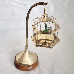 Unusual vintage style miniature brass birdcage on a stand, containing a vibrant green bird on a perch - 19cm tall
