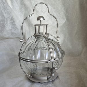 Clear glass ball lantern in silver finish holder with three feet and carry handle - 33cm tall