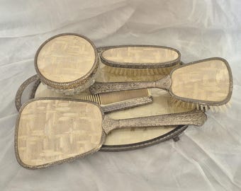 Vintage 6-delat sminkbordsset i silver, utsmyckat med en attraktiv geometrisk design i guld och beige; bricka, spegel, två borstar, kruka och kam