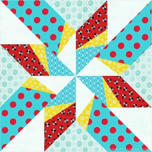 May include: A colorful quilt block with a starburst design. The block is made up of triangles in shades of red, yellow, blue, and white. The fabric has a polka dot pattern and a geometric pattern.