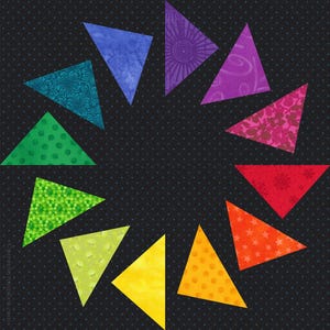 May include: A quilt block featuring twelve triangular fabric pieces arranged in a circular pattern on a black background with small white dots. Each triangle displays a different colour and pattern, including floral, geometric, and star motifs.