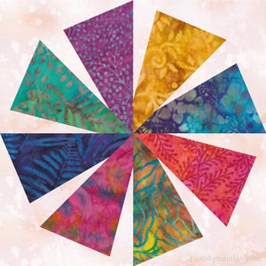 Könnte beinhalten: Ein farbenfrohes Quiltblock-Design mit zehn dreieckigen Segmenten in einem kreisförmigen Muster. Jedes Segment zeigt einen einzigartigen Batikstoff mit leuchtenden Farben wie Lila, Türkis, Gelb, Blau und Rosa, mit botanischen Mustern.