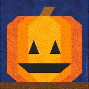 May include: A patchwork pumpkin design with a smiling face, featuring orange, yellow, and black fabrics. The pumpkin has a stem and is set against a dark blue background. The bottom has a brown border. A Halloween-themed craft.