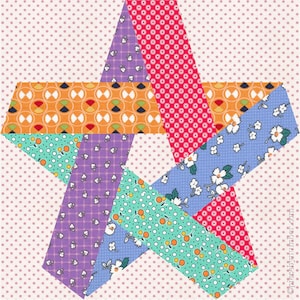 May include: A colorful star-shaped quilt block with various patterned fabrics. The star features orange, purple, red, blue, and green fabrics with polka dots, floral, and geometric designs. The background is a light pink with small white polka dots.