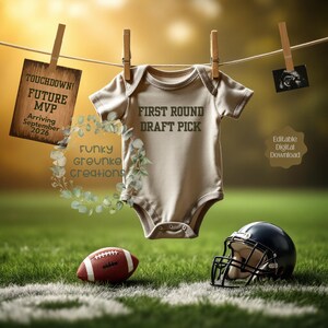 Puede incluir: Un body de bebé beige con el texto "FIRST ROUND DRAFT PICK" cuelga de una cuerda. Un letrero dice "TOUCHDOWN! FUTURE MVP Arriving September 2026." Un balón de fútbol y un casco descansan sobre la hierba.