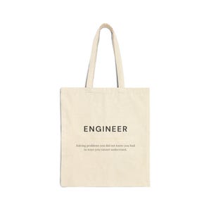 Op de afbeelding: Een beige draagtas met het woord "ENGINEER" in zwarte letters. Daaronder staat de tekst: "Solving problems you did not know you had in ways you cannot understand."