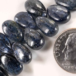 May include: A strand of dark blue gemstone beads in a teardrop shape. The beads are approximately the size of a US dime.