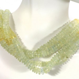 May include: A multi-strand necklace made of light green and yellow gemstone beads. The beads are round and have a slightly irregular shape. The necklace is approximately 18 inches long.