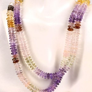 May include: Two layered necklace with a variety of colorful gemstones. The necklace features a gradient of colors, including purple, pink, yellow, and brown. The gemstones are small, round, and evenly spaced, creating a delicate and elegant design.