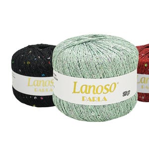 May include: Three balls of yarn with sequins, one black, one green, and one red. Each ball has a label that reads "Lanoso Paria 25 gr".