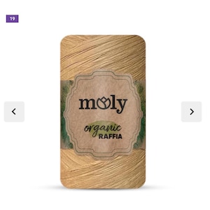 May include: A spool of Moly organic raffia in a light tan color. The label features the brand name "moly" with a floral design and the words "organic raffia" in a script font. The raffia is tightly wound and ready for use.