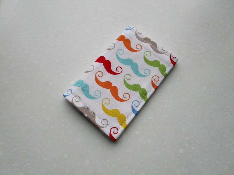 May include: A white fabric pouch with a colorful pattern of mustaches in red, orange, yellow, green, blue, and light blue.