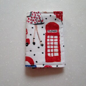 Puede incluir: Una bolsa de tela blanca con una cabina telef&oacute;nica roja, un coche rojo y una mujer con un vestido rojo con lunares negros. La bolsa tiene lunares negros y el texto "TELEPHONE" en la cabina telef&oacute;nica.