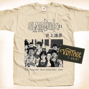 Può includere: Una maglietta vintage beige con una grafica in bianco e nero di giocatori di basket della squadra di basket della Shohoku High School. La grafica include il testo "SLAM DUNK 31" e "井上雄彦".