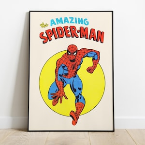 Op de afbeelding: Ingelijste vintage stripboek kunstafdruk met Spider-Man in een dynamische pose. Het kunstwerk toont de superheld in zijn klassieke rood-blauwe pak, tegen een gele cirkel, met de woorden "The Amazing Spider-Man" bovenaan.
